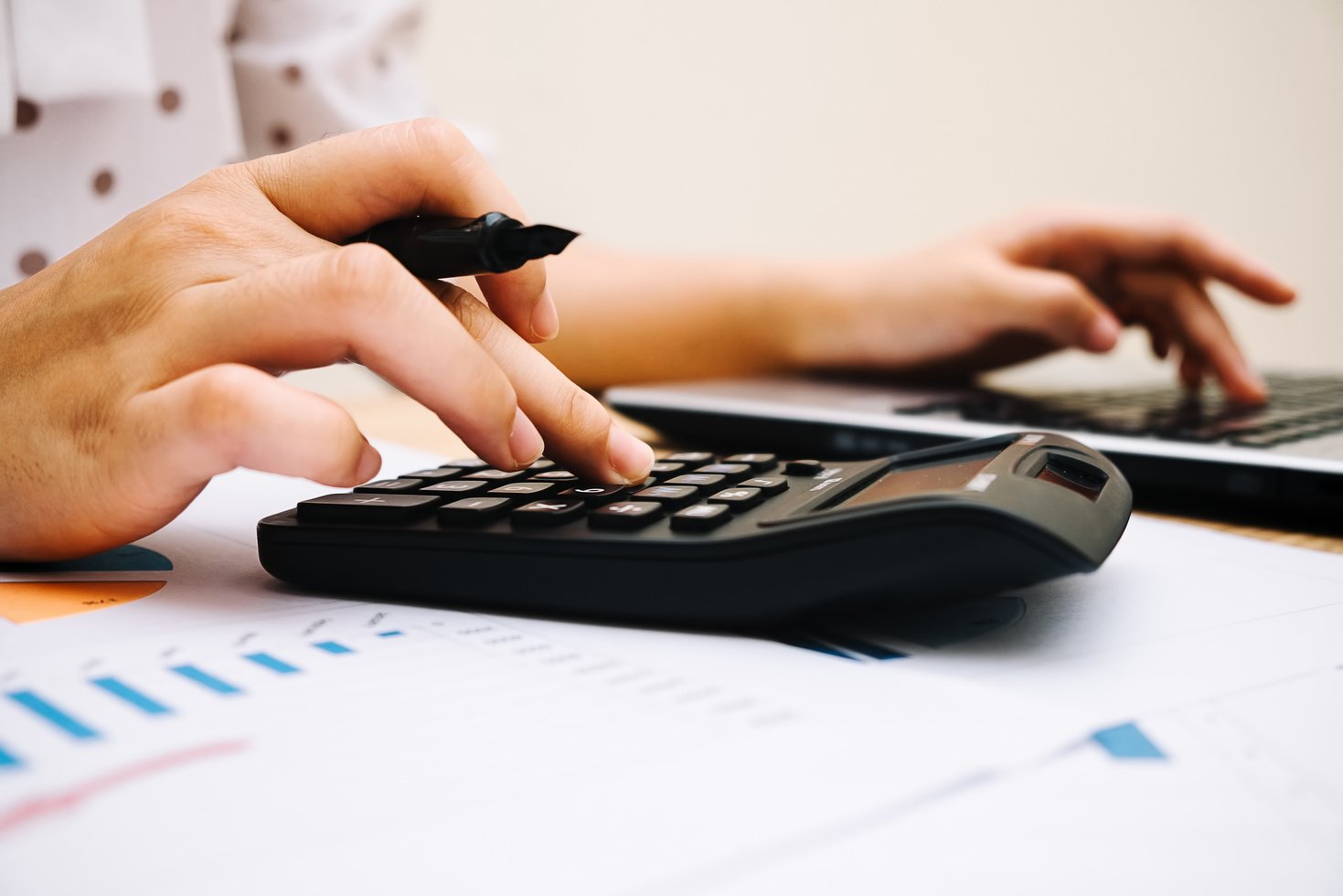 Businesswoman Using a Calculator at Work